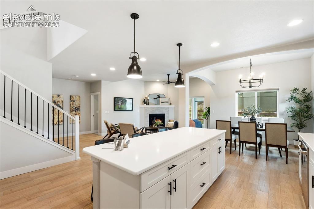 Image 16 of 43: White kitchen island with a solid surface countertop, recessed lighting, wo