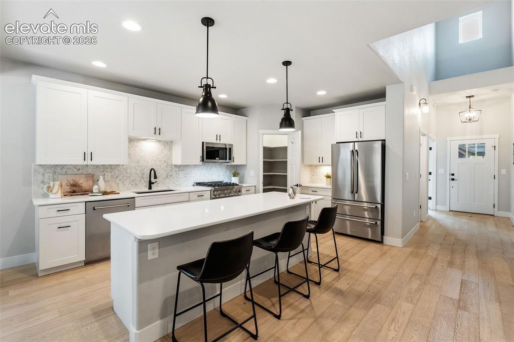 Image 17 of 43: Gourmet kitchen with white cabinetry, stainless steel appliances, a large i