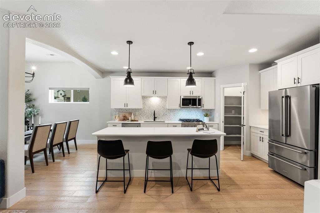 Image 19 of 43: Contemporary kitchen featuring white cabinetry, stainless steel appliances,