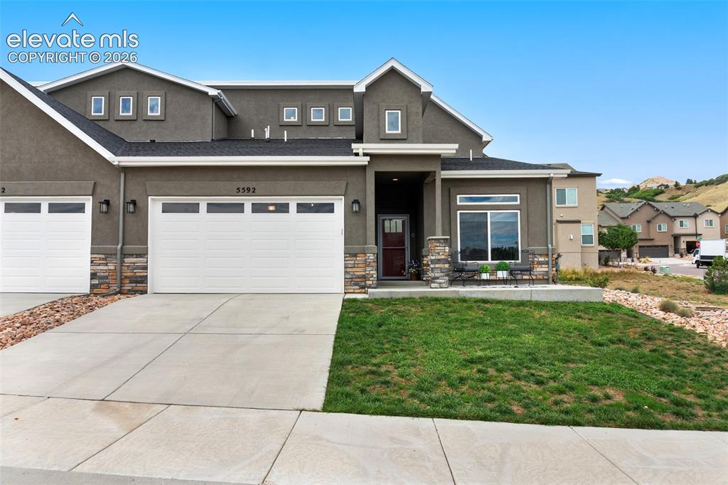 Image 2 of 43: Stucco exterior featuring stone accents, a covered front entry, and a multi