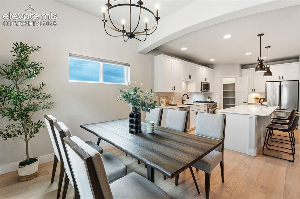 Image 20 of 43: Light wood-finish flooring, white cabinetry with dark hardware, stainless s