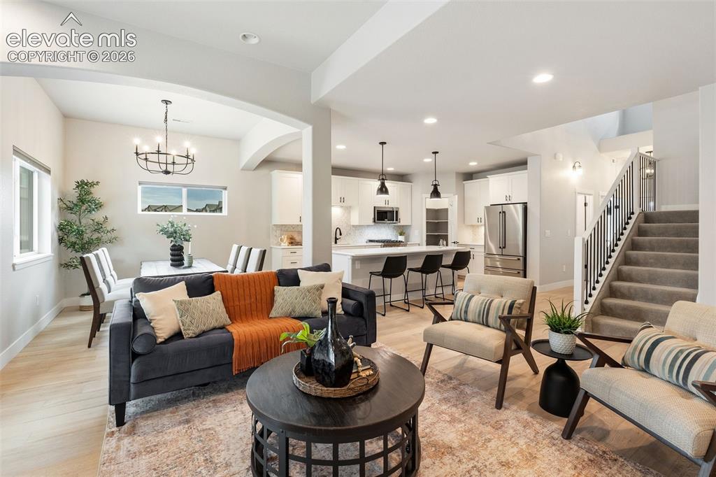 Image 22 of 43: Open-concept living area with wood-finish flooring, recessed lighting, and