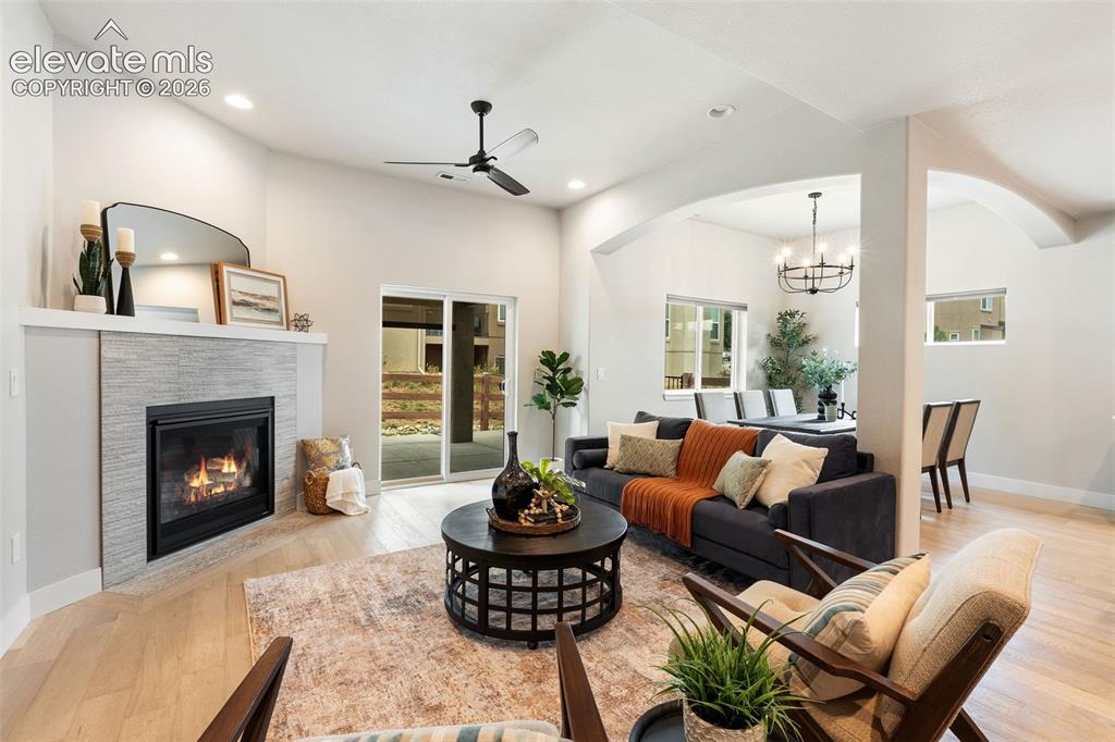 Image 23 of 43: Recessed lighting, light wood-finish flooring, and a fireplace with a light