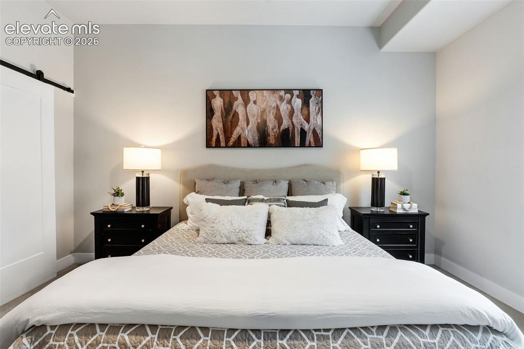 Image 27 of 43: Sliding barn door entry, recessed lighting, and a neutral color palette