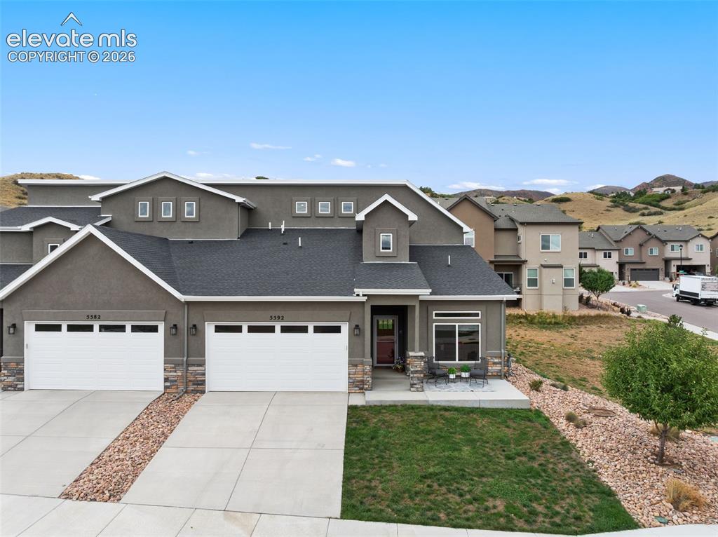 Image 3 of 43: Stucco exterior with stone accents and asphalt shingle roofing