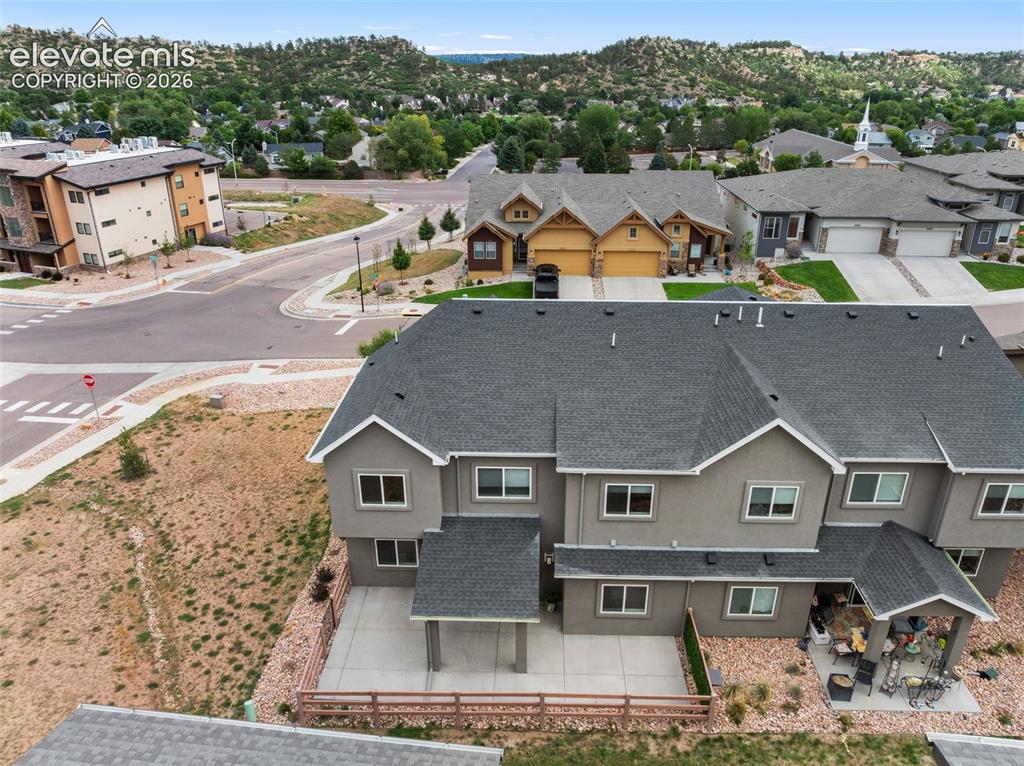 Image 4 of 43: Multi-level stucco exterior with dark gray roofing