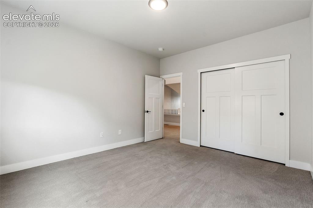 Image 40 of 43: Neutral wall color, gray carpet, white trim, recessed lighting, and a close