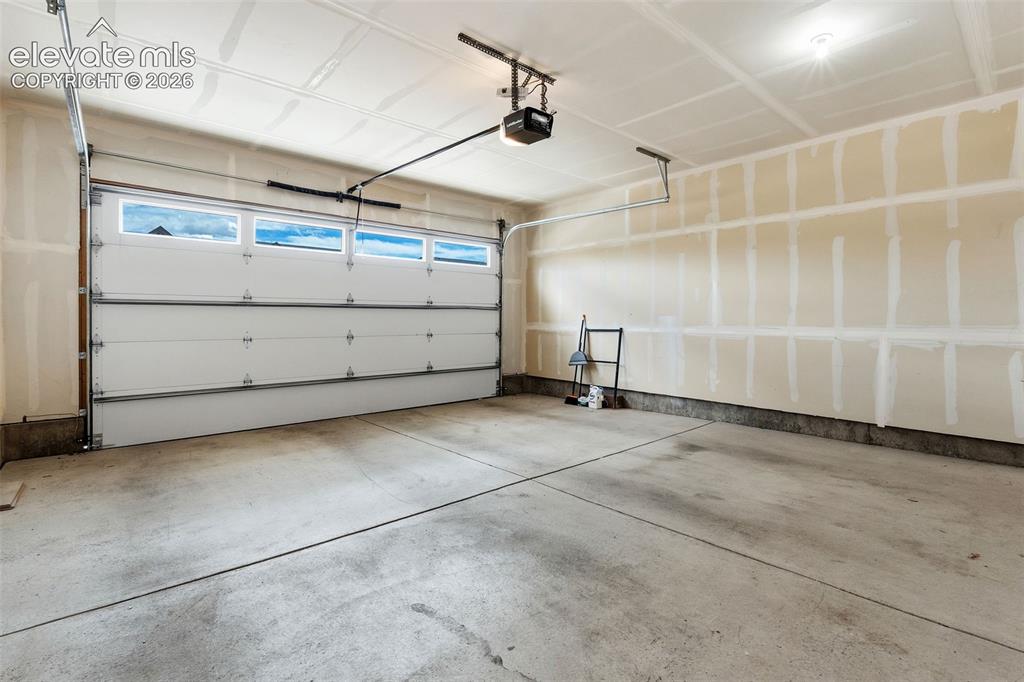 Image 43 of 43: Attached garage featuring a concrete floor, automatic garage door opener, a