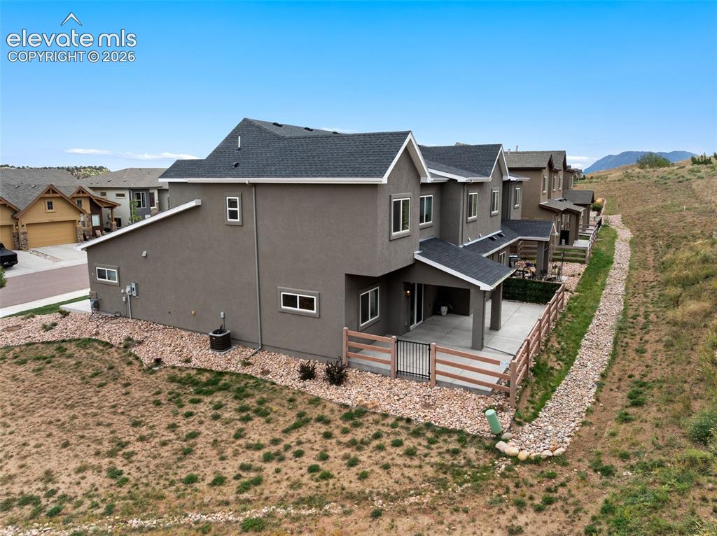 Image 7 of 43: Contemporary stucco exterior with a covered patio, fenced outdoor area, and