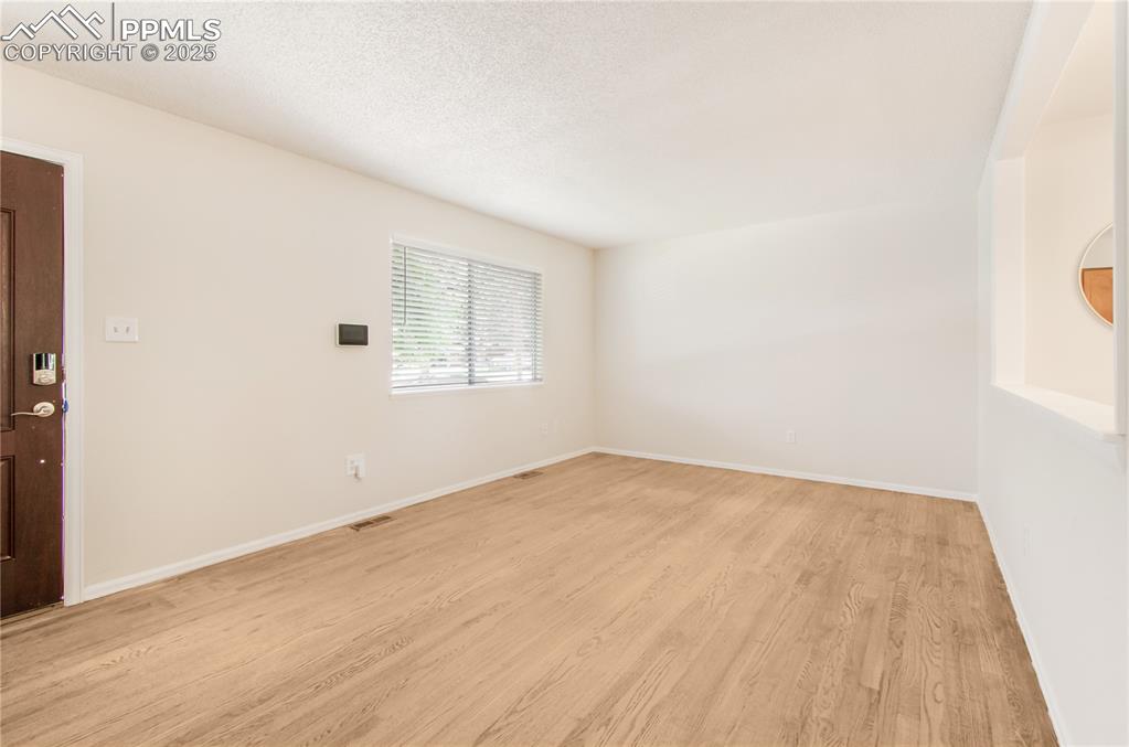 Image 10 of 25: Living room with light wood-style floors and baseboards
