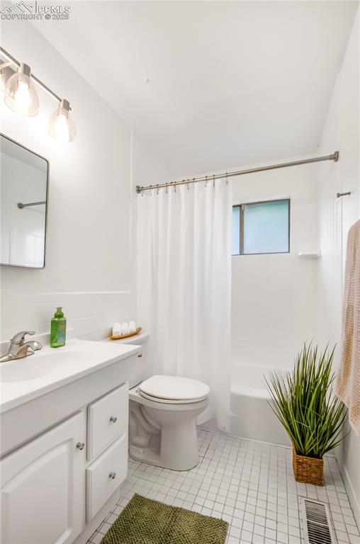 Image 11 of 25: Bathroom featuring vanity, shower / bathtub combination with curtain, and t