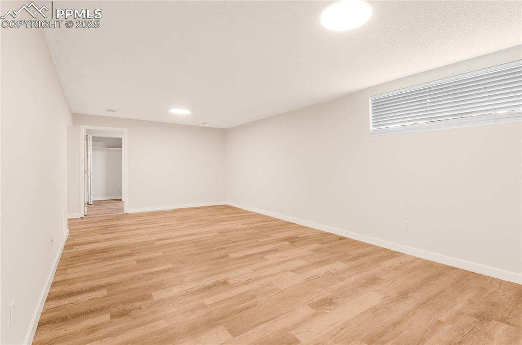 Image 18 of 25: Family room area with light wood-style flooring