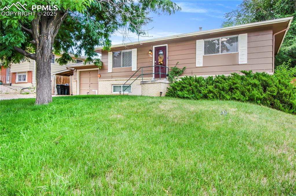 Image 27 of 27: View of front facade featuring an attached garage and a front lawn