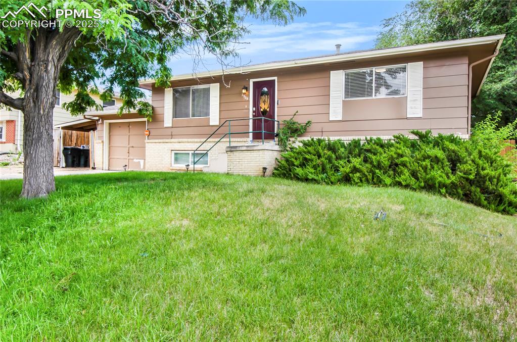 Image 3 of 25: View of front of house with a front yard and a garage