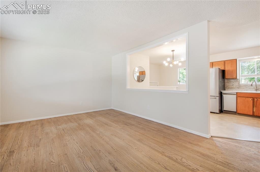Image 8 of 25: Living room with a chandelier and light wood finished floors