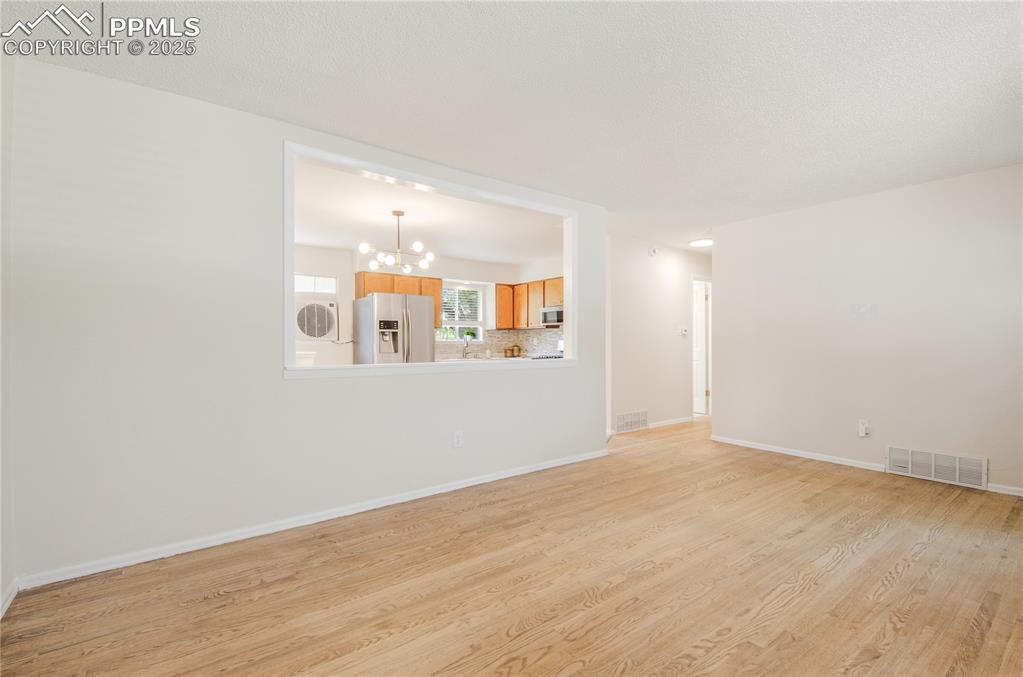 Image 9 of 25: Living room featuring a chandelier and light wood-style flooring