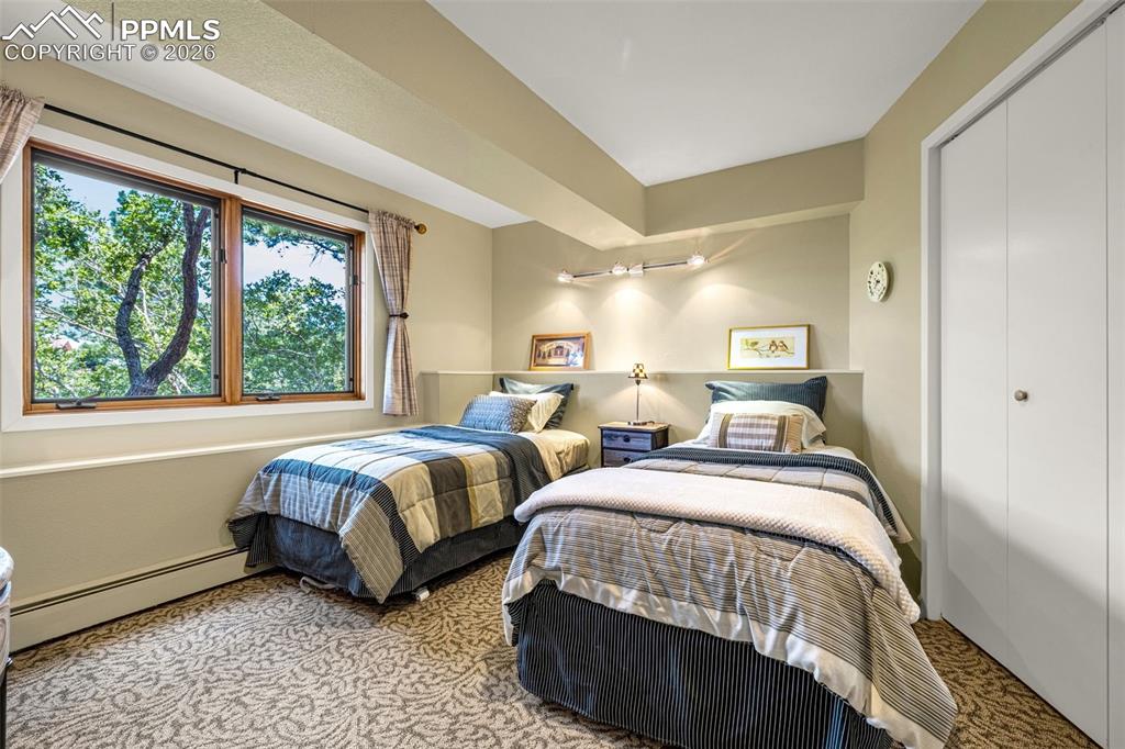 Image 11 of 42: Carpeted bedroom with a baseboard radiator and a closet