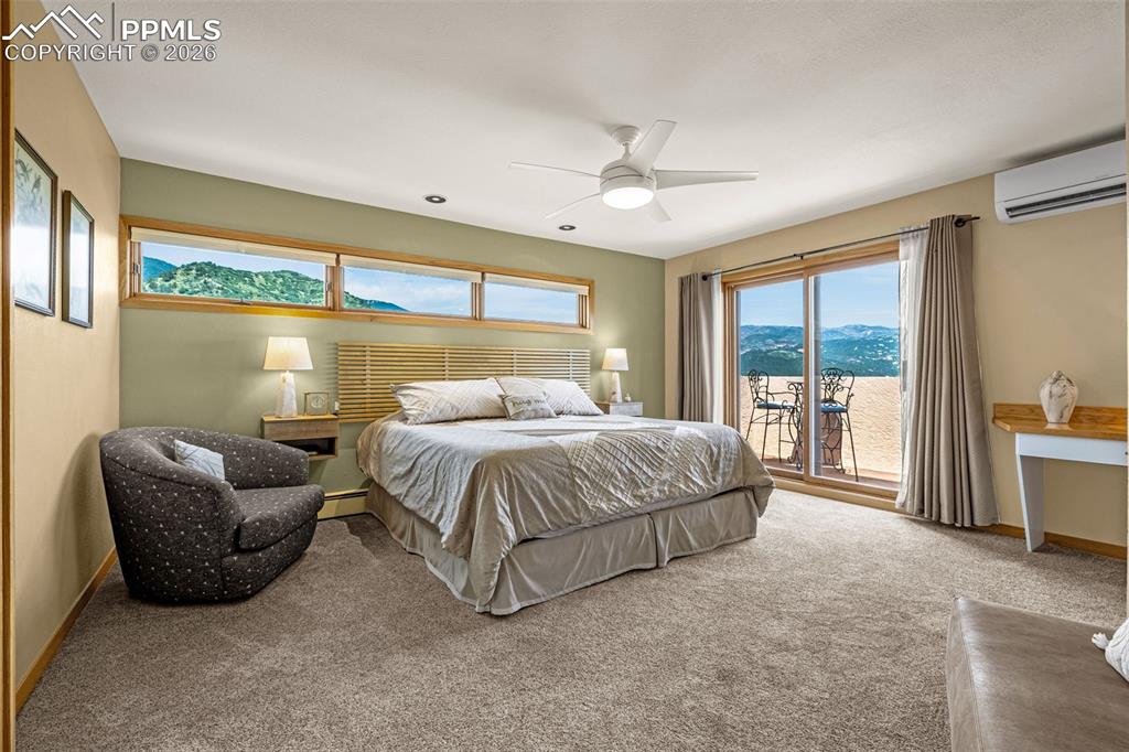 Image 8 of 42: Carpeted bedroom with a mountain view, multiple windows, and ceiling fan