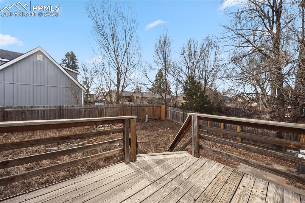 Image 13 of 27: Backyard deck with stairs to the backyard. 