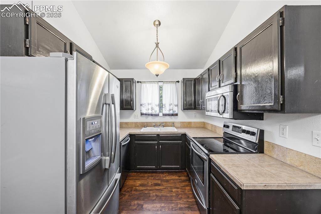 Image 9 of 27: The updated eat-in kitchen showcases espresso cabinetry, tile countertops, 