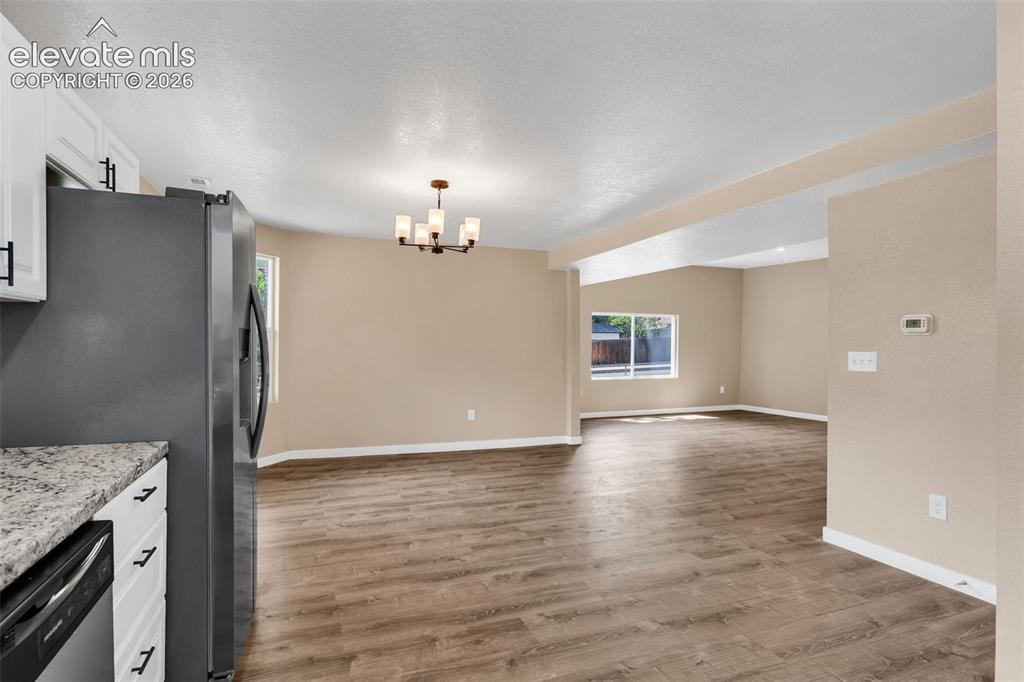 Image 20 of 50: Open-concept living area with wood-finish flooring, recessed lighting, and