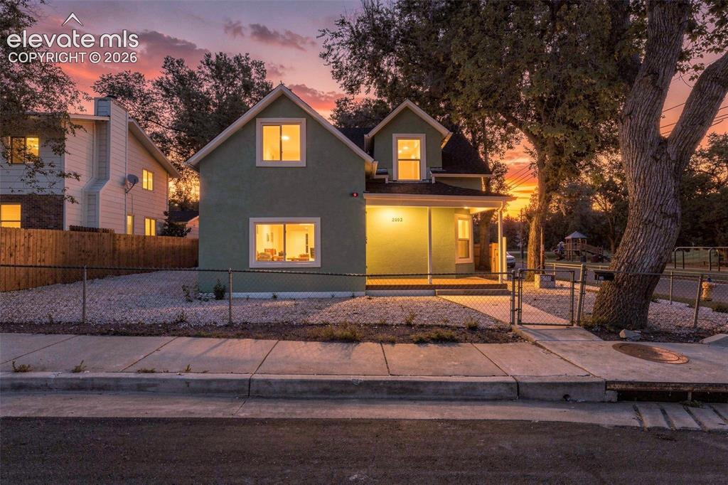Image 4 of 50: Two-story residence with a covered porch, featuring a gravel front yard and