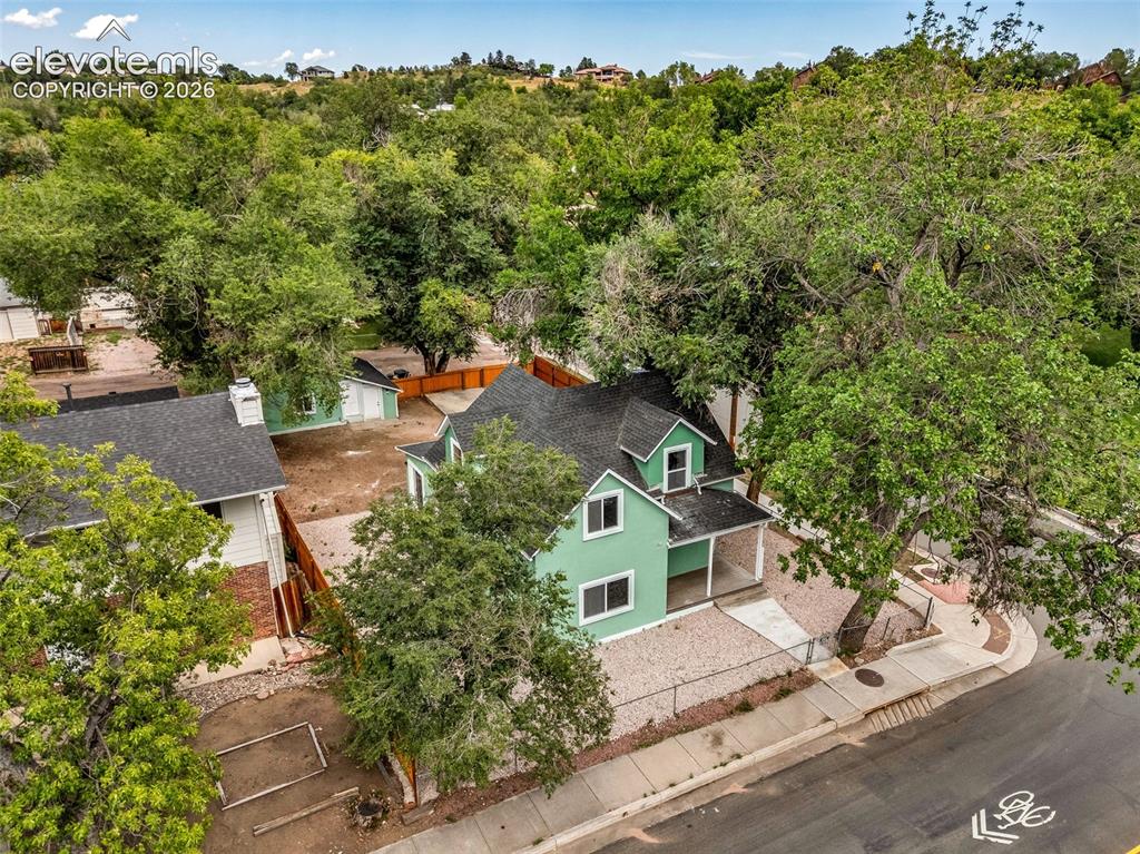 Image 42 of 50: Mint green exterior with white trim, dark asphalt shingle roof, covered fro