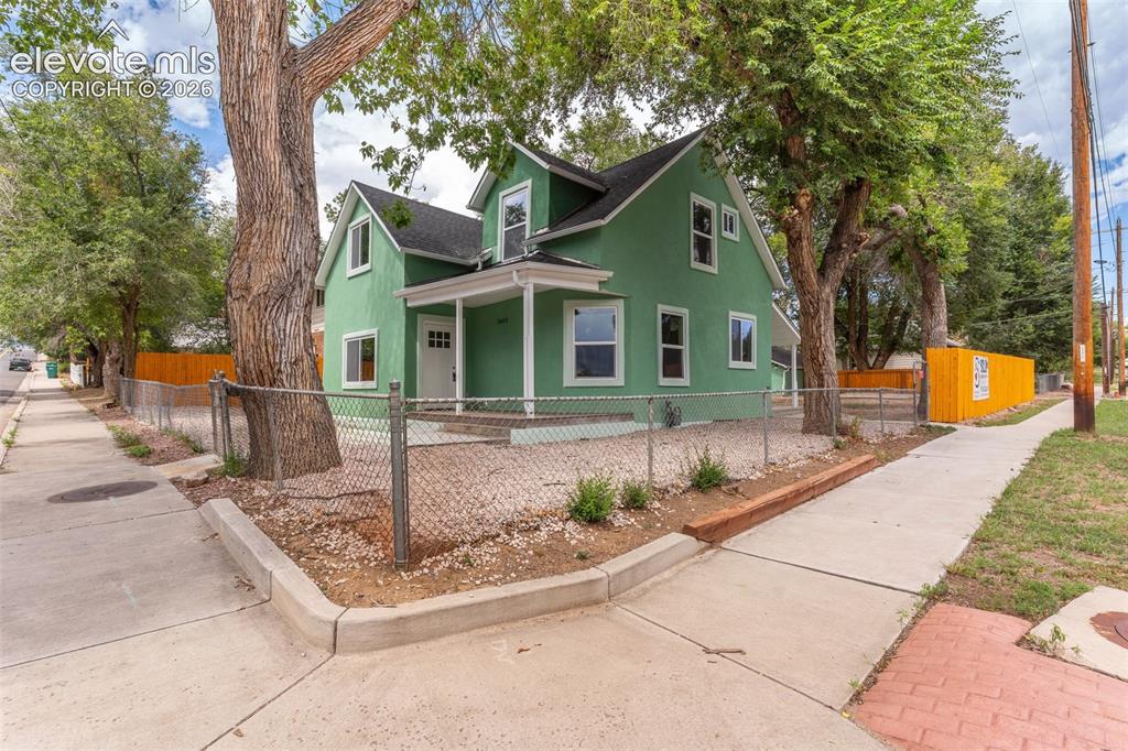 Image 46 of 50: Green exterior siding with white trim, covered front porch, white front doo