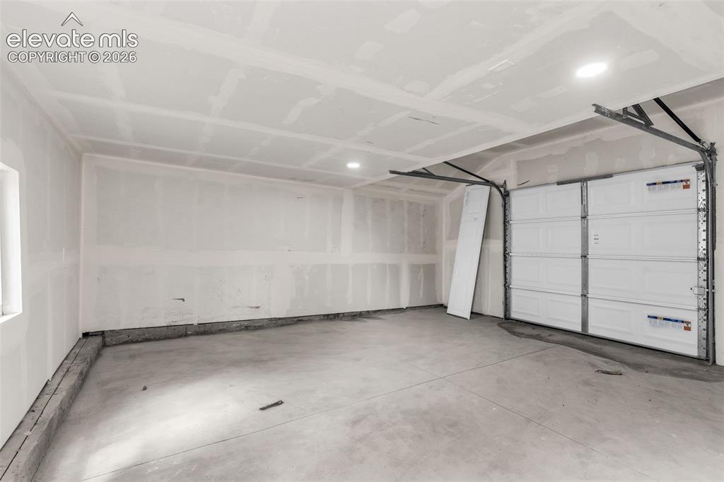 Image 49 of 50: Concrete flooring, drywall ceiling with recessed lighting, and a white pane