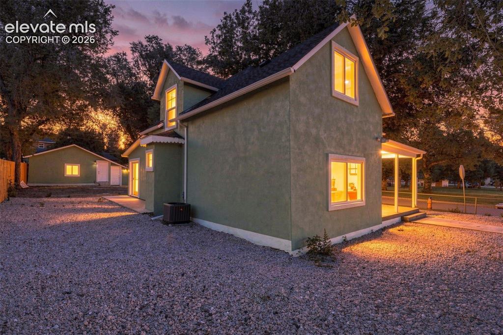 Image 6 of 50: Stucco exterior with contrasting trim, gable roofline, covered porch, grave