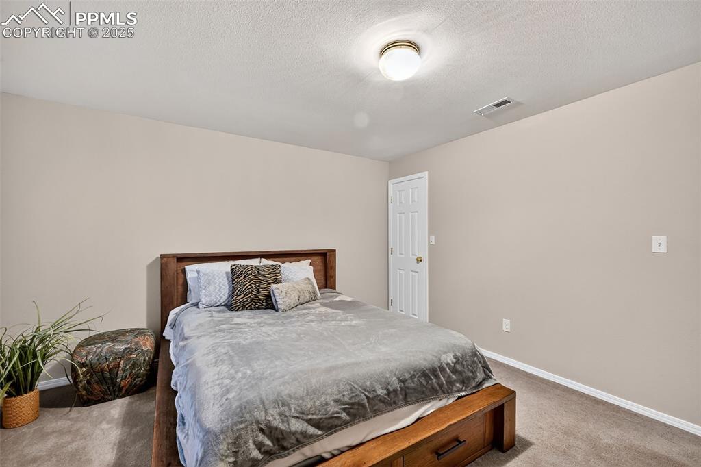 Image 29 of 41: Bedroom #3 featuring light colored carpet and a textured ceiling.