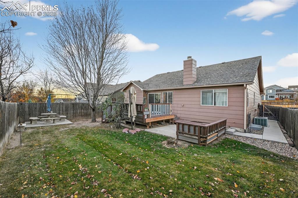 Image 34 of 41: Rear view of property with a fenced backyard, a wooden deck, a patio, and a