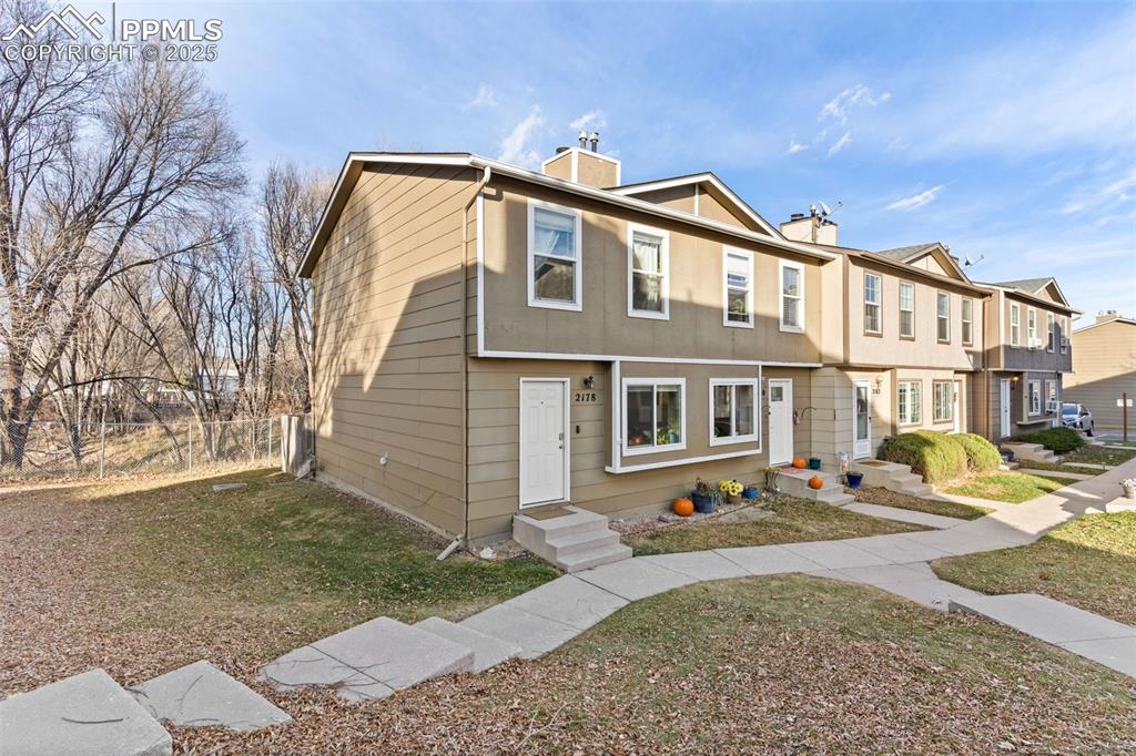 Caption: Colonial home with a chimney, a residential view, and entry steps