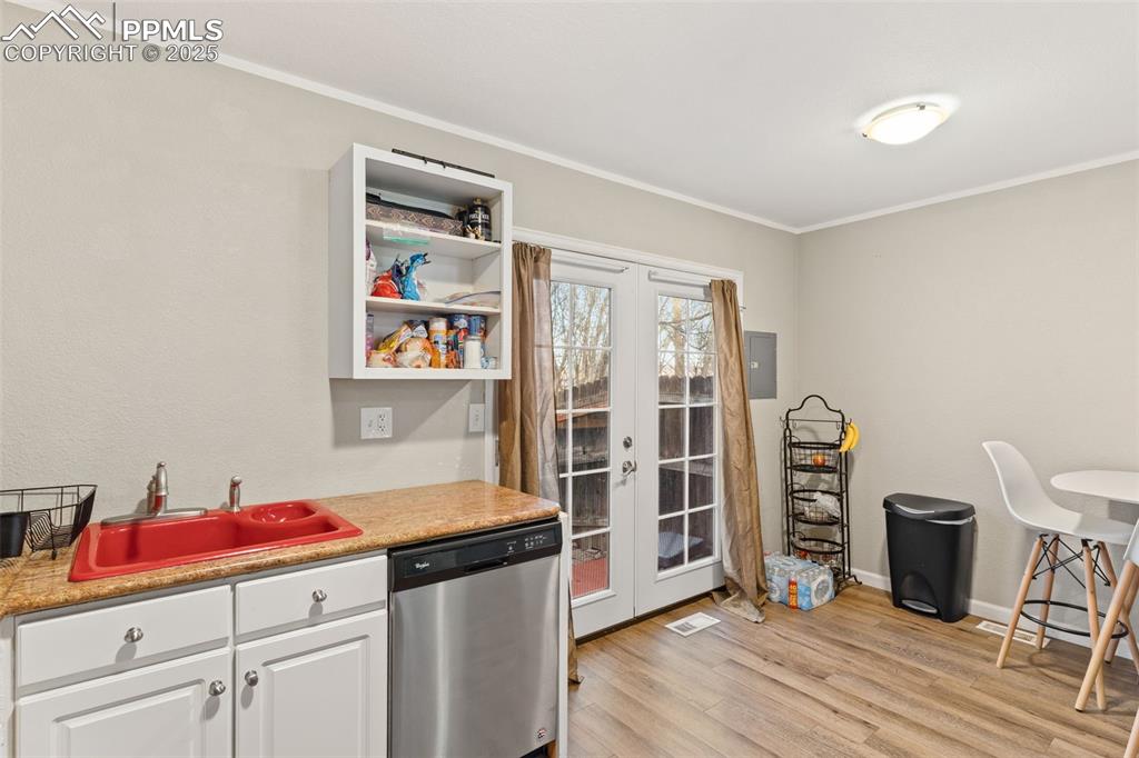 Image 9 of 26: Kitchen with open shelves, dishwasher, white cabinets, french doors, and li