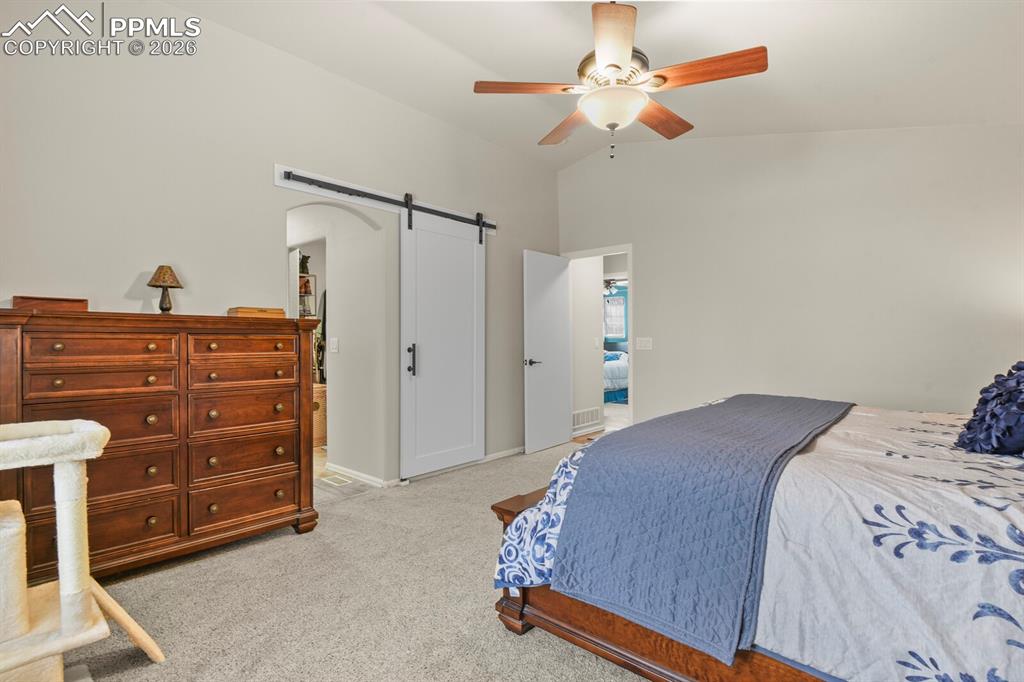 Image 24 of 43: Barn door leading into the primary en suite bathroom