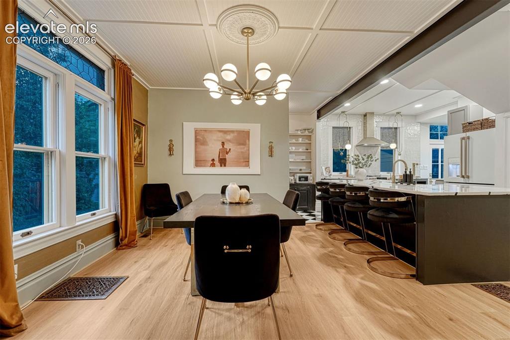 Image 19 of 50: Dining area with wood-finish flooring, a decorative ceiling medallion, and 