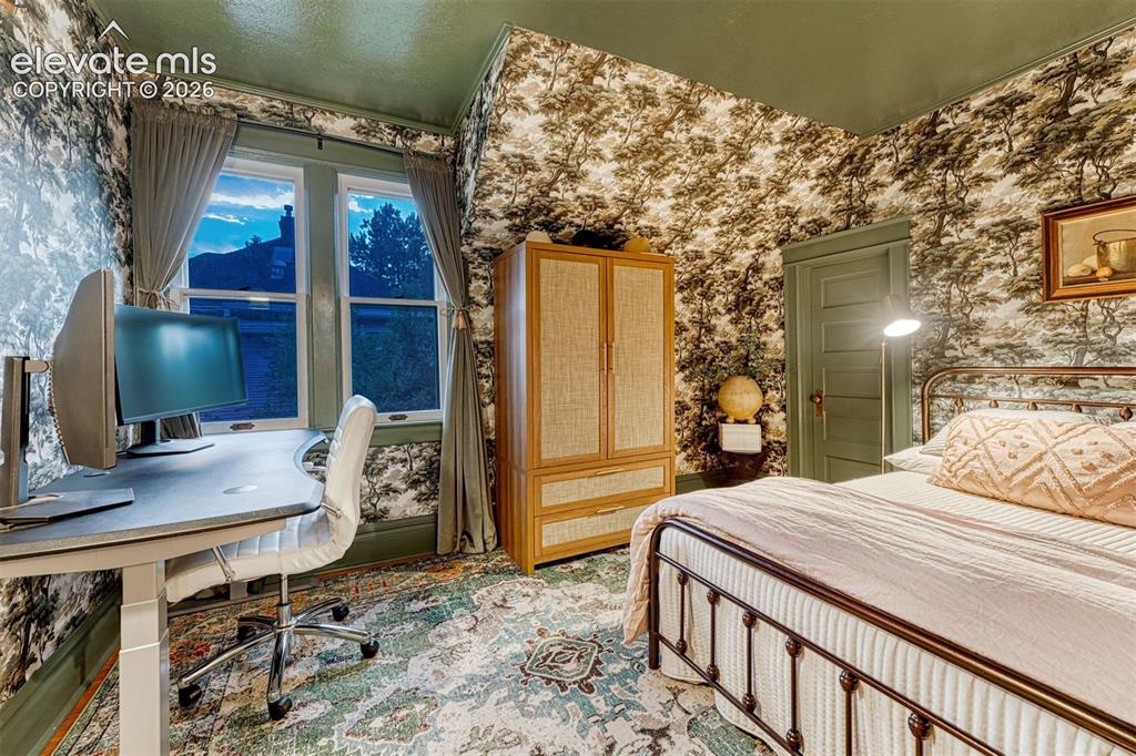 Image 36 of 50: Patterned wallpaper, painted trim, and a high ceiling