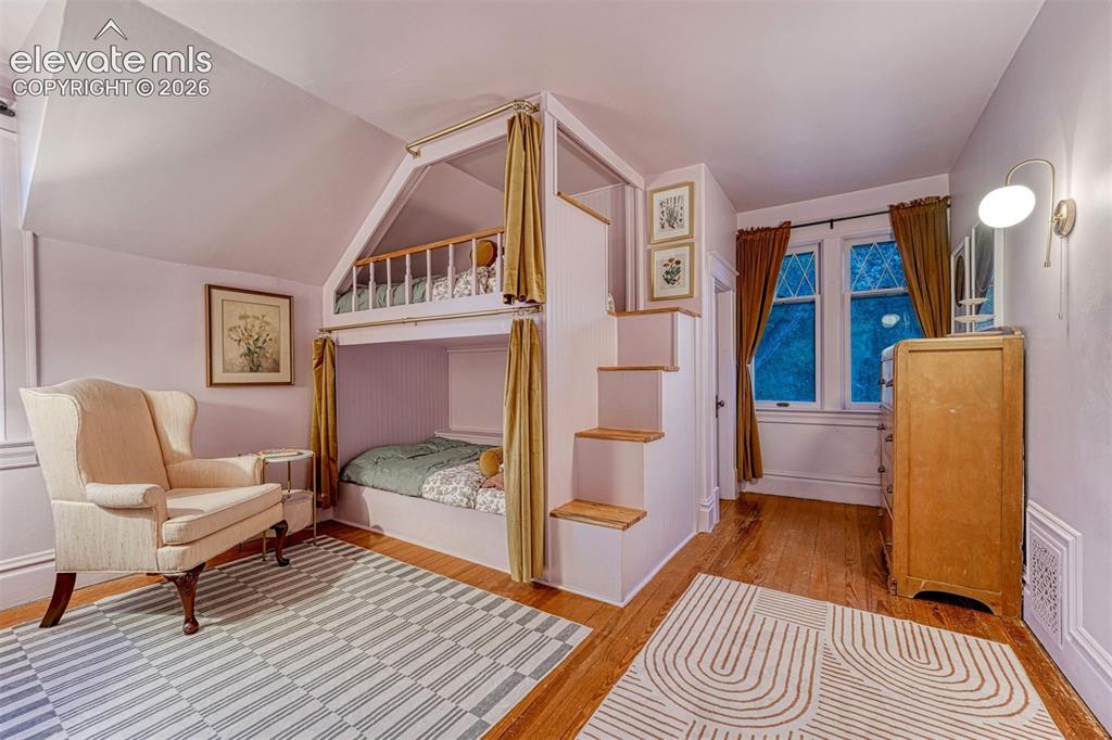 Image 38 of 50: Built-in bunk beds with integrated staircase, rich wood-finish flooring, an