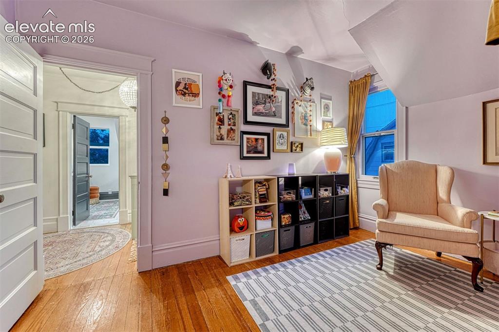 Image 39 of 50: Hardwood flooring, painted interior door with traditional trim, window with