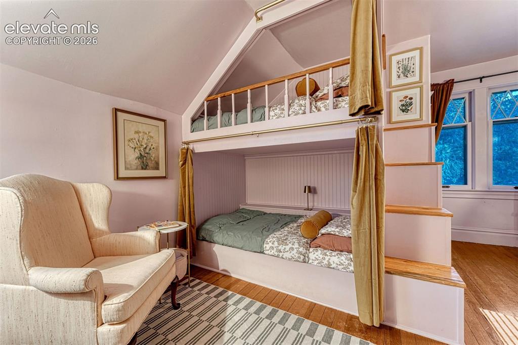 Image 40 of 50: Built-in bunk beds with integrated stairs, hardwood flooring, and architect