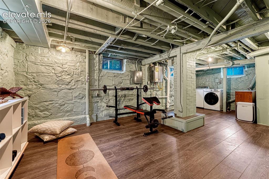 Image 47 of 50: Finished basement space featuring wood-finish flooring, exposed ceiling joi