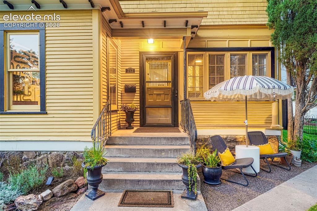 Image 6 of 50: Yellow horizontal siding facade featuring a concrete front porch, multiple 