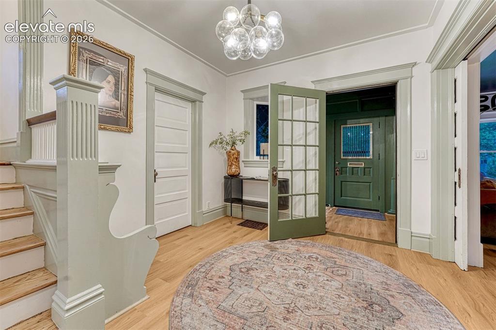 Image 9 of 50: Hardwood flooring, decorative staircase newel post, glass-paneled entry doo