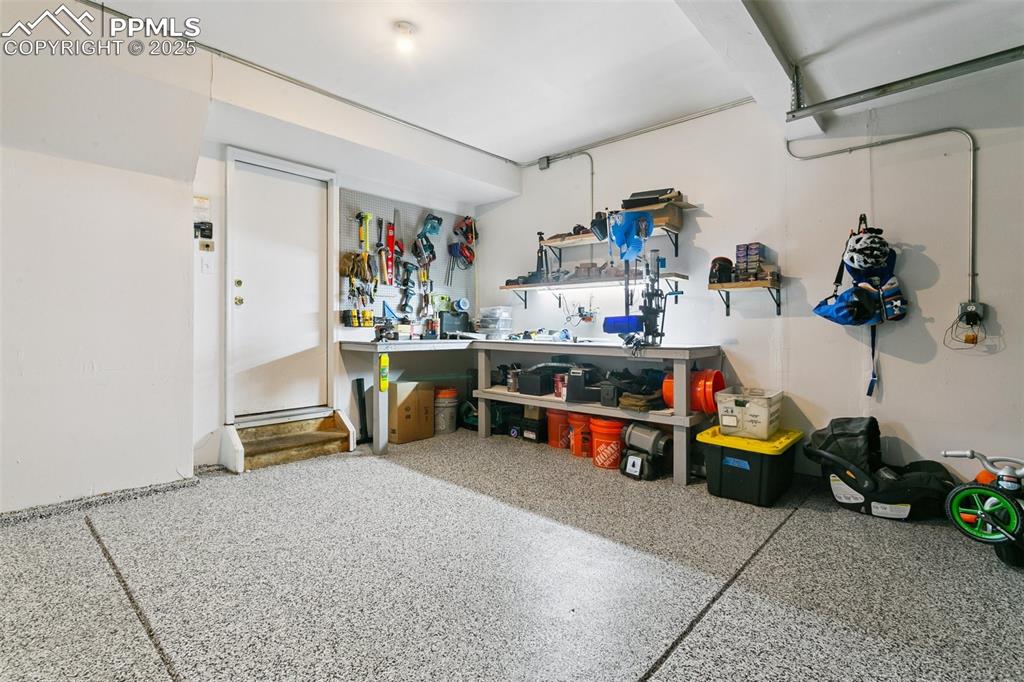 Image 34 of 41: Garage has epoxy floors with work bench and a deep third bay space.