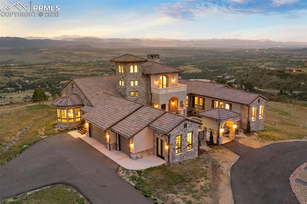 Caption: Mediterranean-inspired estate glowing at golden hour, perched atop a private mesa with sweeping Fron