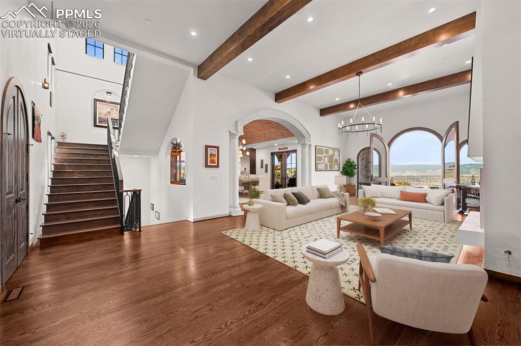 Image 13 of 39: Beautiful great room with soaring ceilings, exposed beams, and arched doors