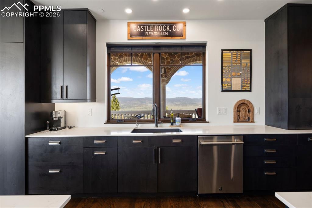 Image 18 of 39: Kitchen sink with Front Range views framed by the stone arch beyond.