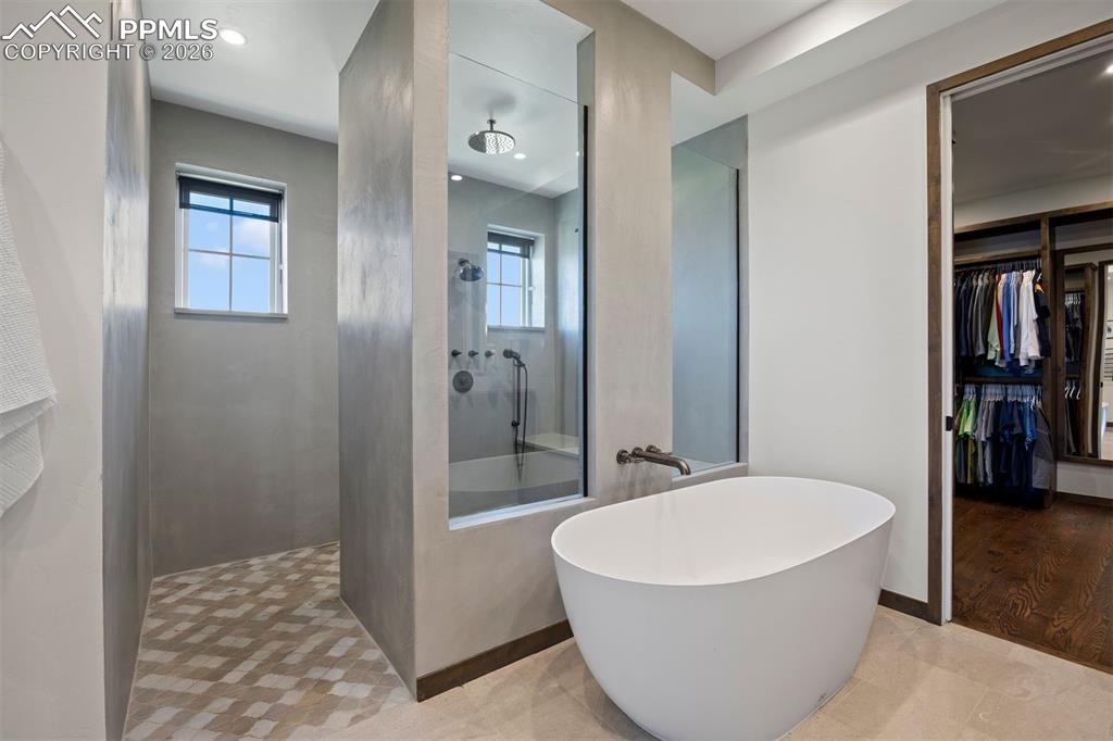 Image 22 of 39: Primary bath with freestanding soaking tub, oversized walk-in shower with r