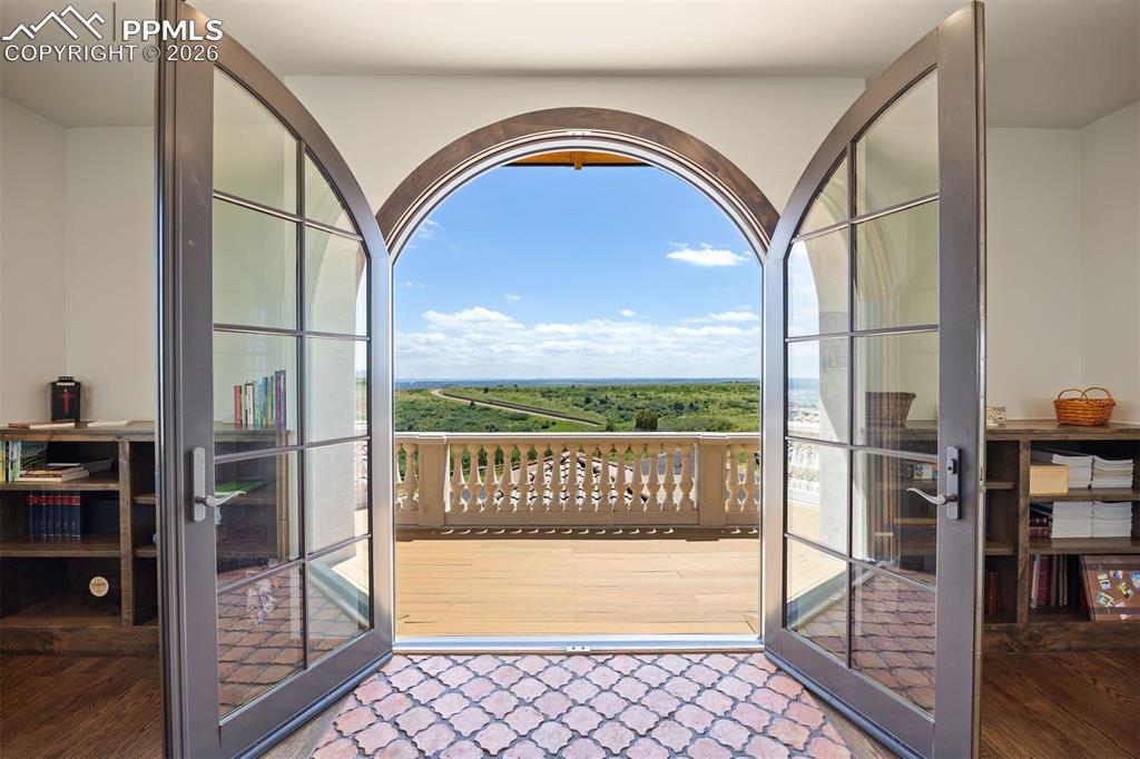 Image 25 of 39: Twin balconies with arched French doorsoverlooking mountain views to the We