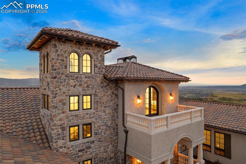 Image 37 of 39: Main-level guest suite with Juliet balcony, vaulted ceiling, and private en
